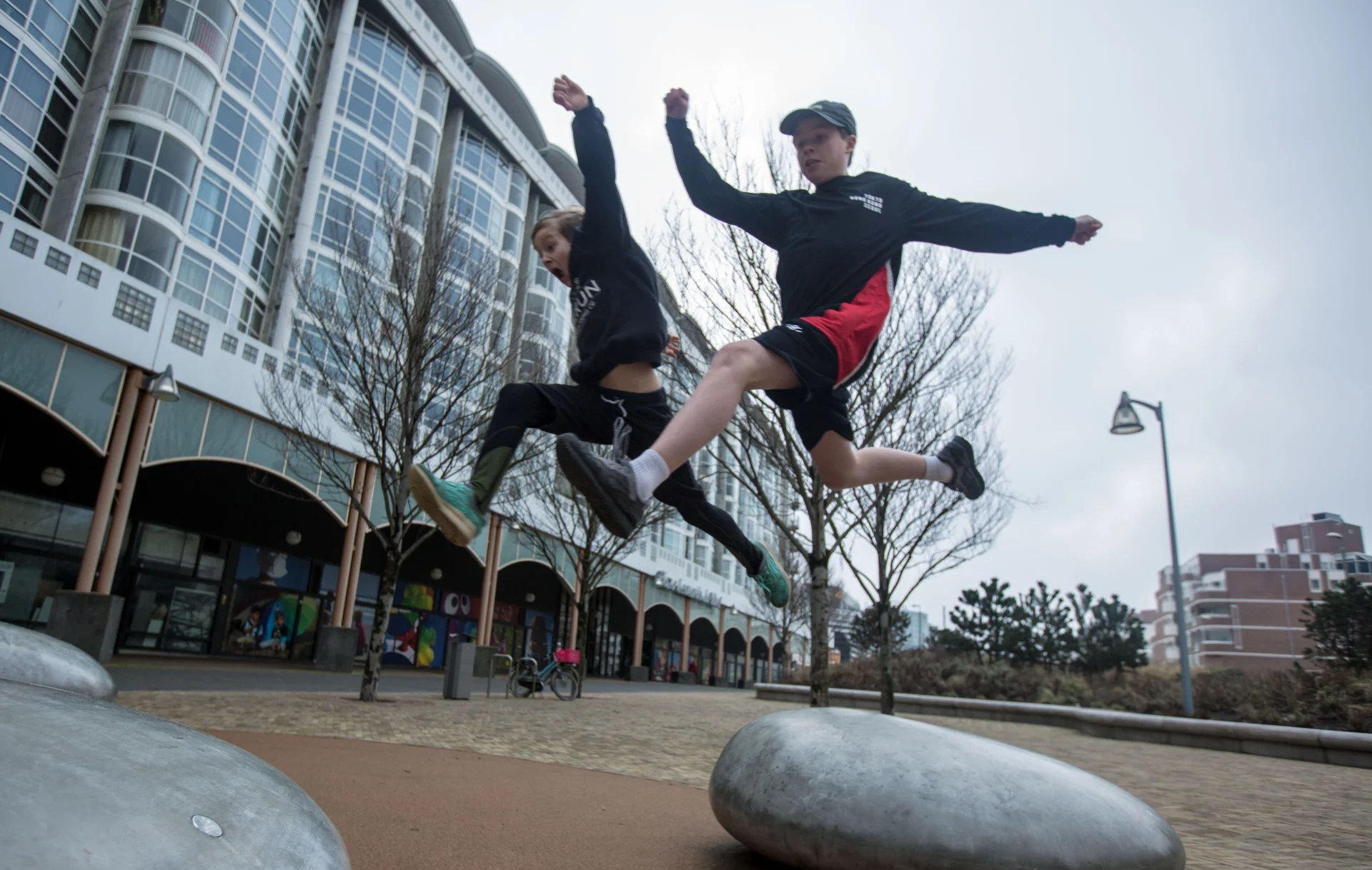 DAREcademy-coach begeleidt een leerling bij een freerun-oefening