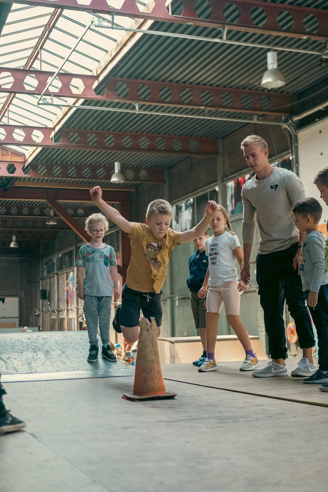 DAREcademy-coach geeft aanwijzingen aan leerlingen tijdens een freerunles in de gymzaal