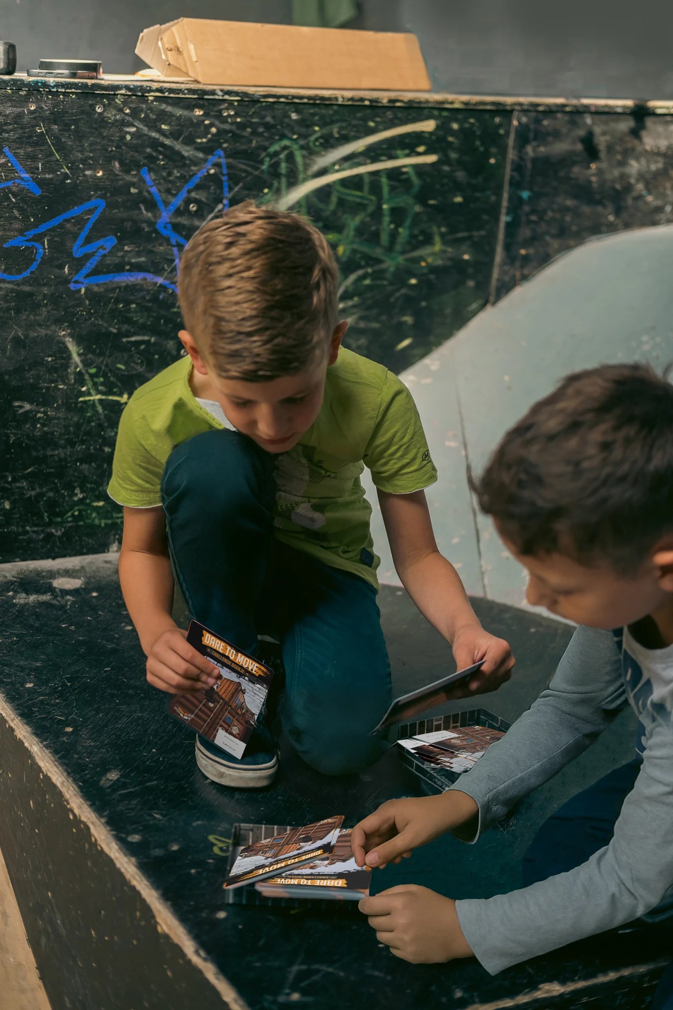 Freerun-coach spot een leerling bij een sprong over een schuine schans