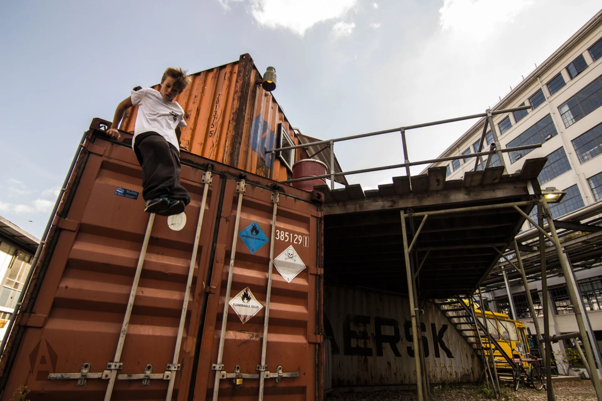 Coach helpt een leerling bij het oefenen van een landing tijdens de freerunles