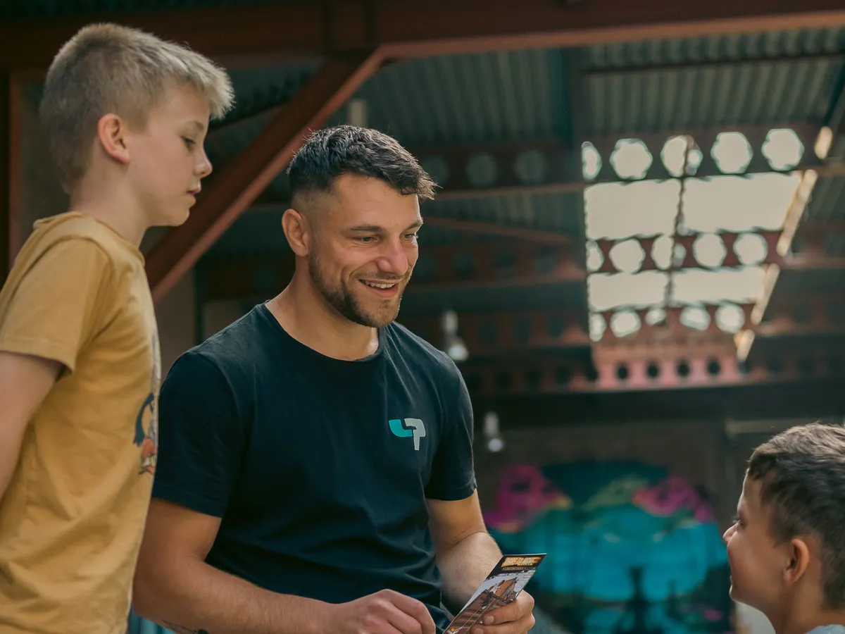 Coach neemt na de les het challengeboekje door met leerlingen